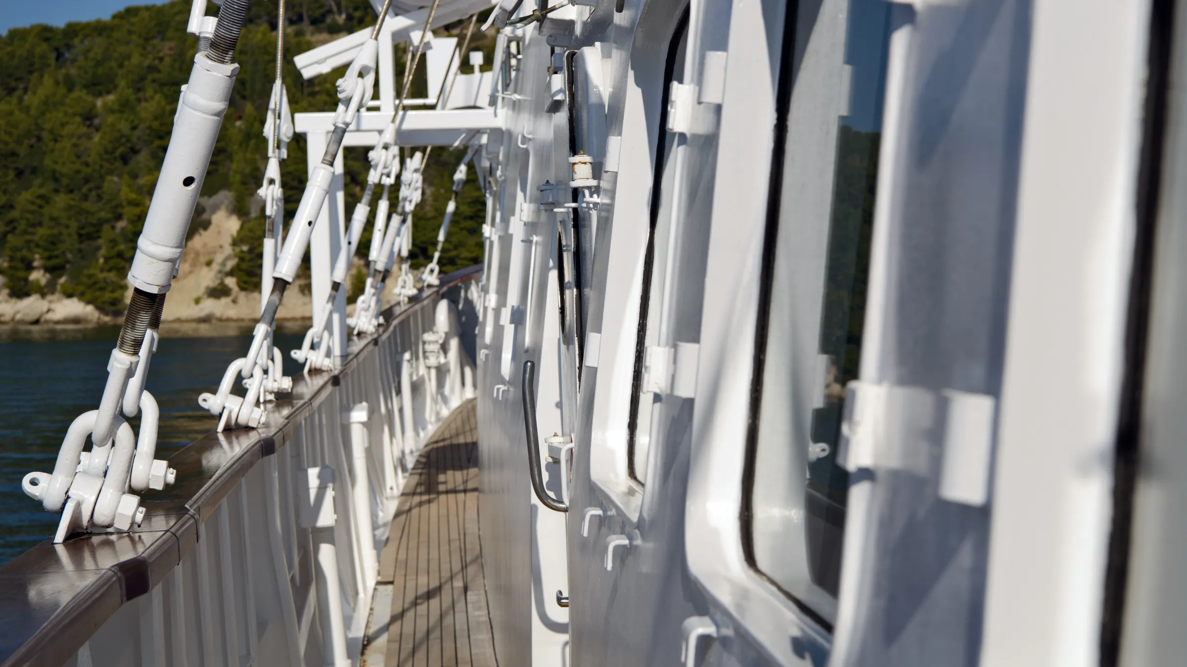Close-up of a ship deck with white structures and sea view.