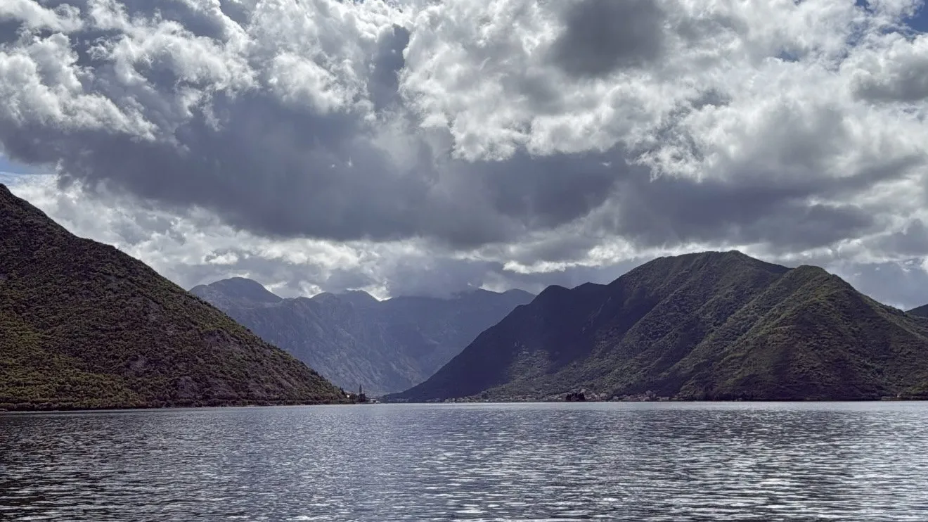 Cloudy sky over a serene mountain lake.