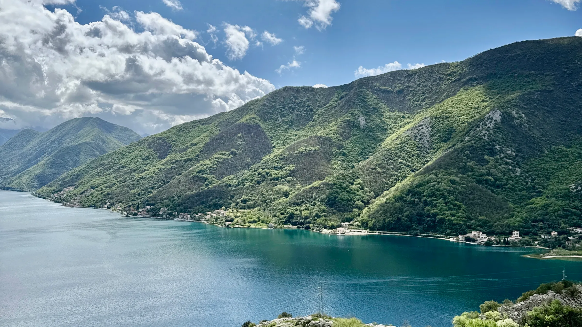 Scenic view of a lake with mountains and cloudy sky.