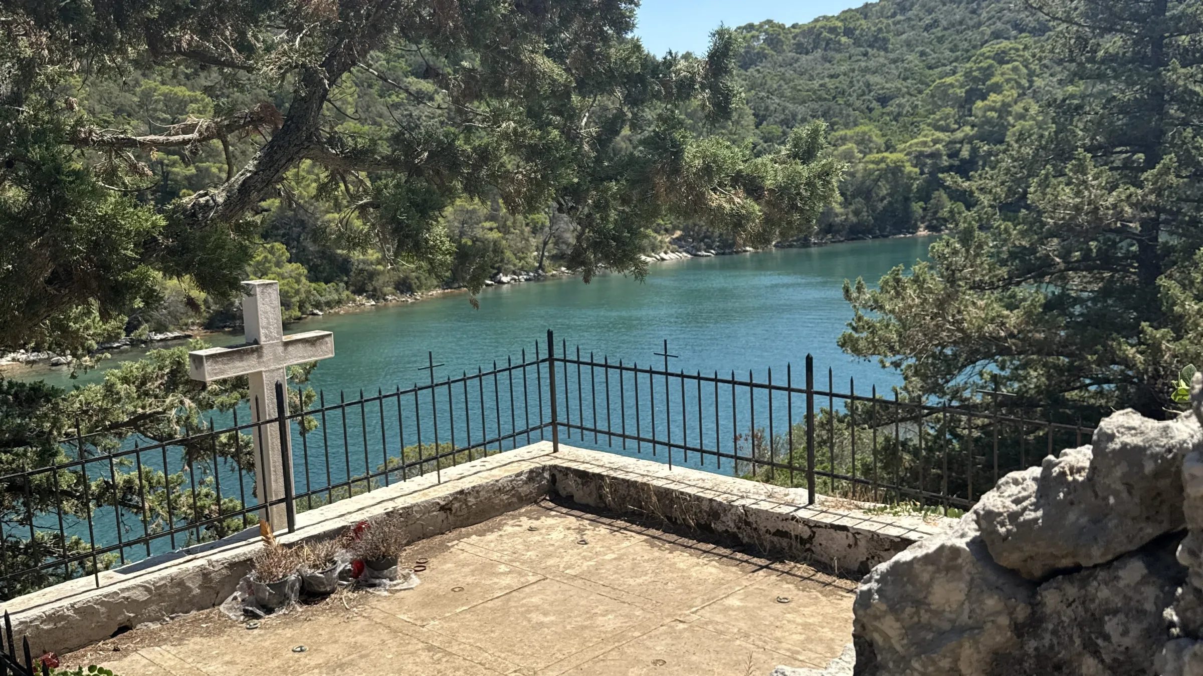 Stone structure with trees and a lake in the background.